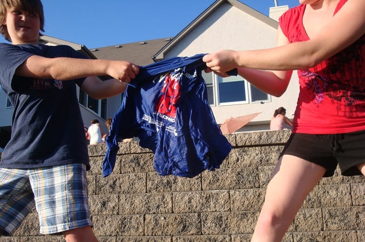 kids trying to unfold a tshirt